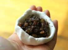 叶儿粑,取一小剂,大概30克一剂,窝起来,像包汤圆一样,包入芽菜肉末馅