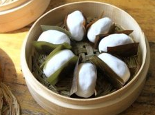 叶儿粑,粽子叶剪成这样的长方形,每个上面刷层薄油,放入包好的糯米团,两边的叶子像这样合上来。做好后的叶儿粑就摆到蒸笼里