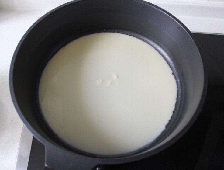 芒果千层蛋糕,面糊舀一勺倒入平底锅,小火加热,并旋转使面糊均匀涂抹在锅底,尽量转的圆一点。