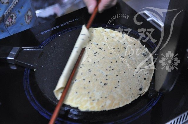 奶香蛋卷 ,取一双筷子，一上一下，将饼挑起，帮助滚动