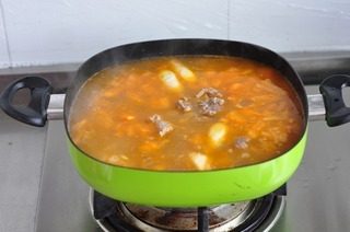 茄汁牛排骨火锅,倒入牛骨汤,调味,小火炖半小时即成为汤底。喜欢辣的可以加点青红尖椒一起煮,酸辣酸辣的也特别好吃