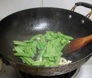 香肠炒荷兰豆,下入摘洗好的<a style='color:red;display:inline-block;' href='/shicai/ 81'>荷兰豆</a>翻炒几下