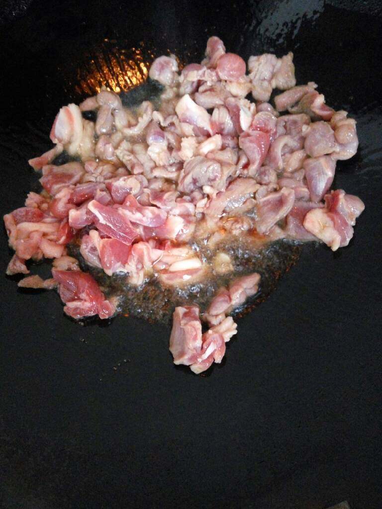羊肉手抓饭,热锅倒油,放入羊肉翻炒至变色