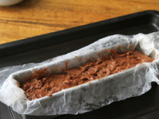 榛果巧克力蛋糕,模具中热烘焙用纸,把拌好的蛋糕糊倒入模具中,抹平