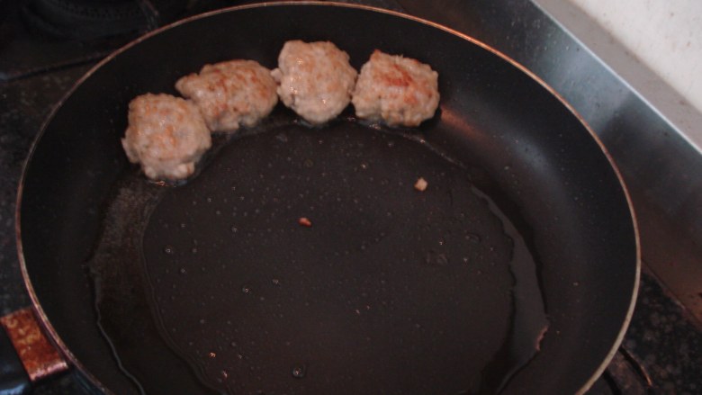 下饭肉饼,煎锅下油,等油沸腾,把捏好的猪肉饼放在锅里,小火煎。