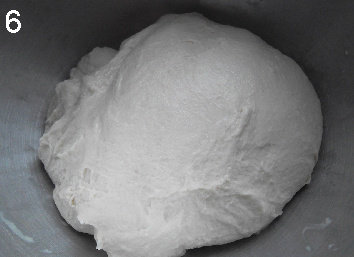 法式面包Fougasse 香油蓝乳酪版,面团放入抹了油的容器里。表面搭上亚麻布,进行发酵。在第30和第60分钟时,手沾湿,将面团拉扯,折两次三折再放回。面团在每次拉扯后都能感到明显的变化,会变得更有光泽。一共发酵90分钟。90分钟后的面团光滑有光泽,体积饱满