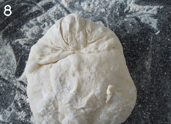 法式面包Fougasse 香油蓝乳酪版,将面团收口朝上,6点和12点的方向摆放。12点方向,像小时候叠飞机时一样,将两个角往中间折。压一压