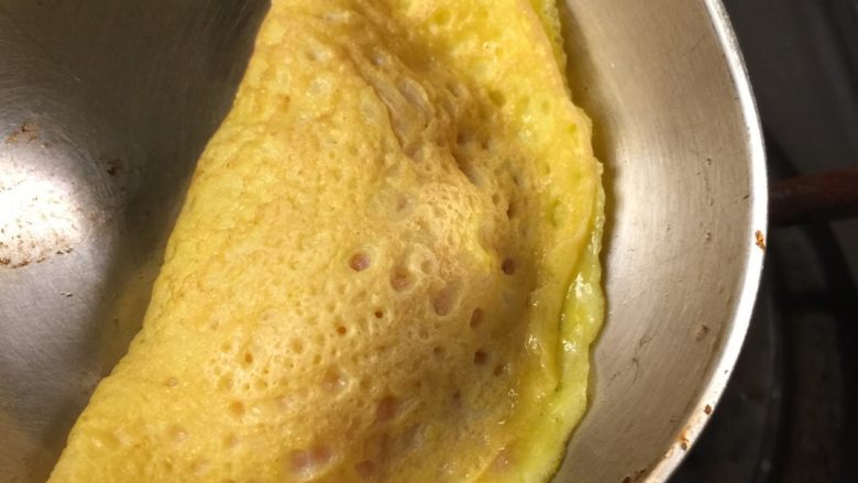 蛋饺,把肉馅放在蛋皮中间,蛋皮对折,利用未凝固的蛋液将蛋皮封口。