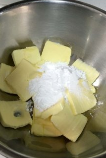 香蕉核桃磅蛋糕,将黄油放入盆软化,用打蛋器搅拌柔软,然后分次加入糖粉,打发黄油