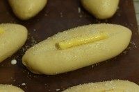 砂糖餐包,放入烤盘,最后发酵1个小时,约2倍大,发酵温度约36度。面团发酵好后,在表面刷上<a style='color:red;display:inline-block;' href='/shicai/ 219'>牛奶</a>,表面划出一条口子,挤上一条黄油,撒上粗糖。(刷<a style='color:red;display:inline-block;' href='/shicai/ 219'>牛奶</a>或者蛋液或者<a style='color:red;display:inline-block;' href='/shicai/ 156925'>水</a>都可以,为的是让砂糖可以多粘在面包表面上。)