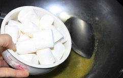手工牛轧糖,棉花糖融化后加入开心果仁和花生即可关火,炒均匀,接着,倒入奶粉拌均匀