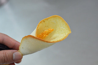 马蹄莲蛋卷,放入150℃的烤箱中烤至圆饼周边微微发黄,用铲刀一片片铲起,迅速裹在花枝上,速度要快,蛋卷刚出炉是软的,稍凉会立刻变脆