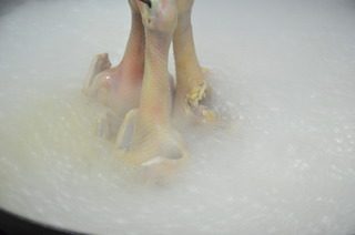 脆皮乳鸽,锅中加水烧开,把腌制好的鸽子放入水中烫一下捞出,收紧<a style='color:red;display:inline-block;' href='/shicai/ 5269'>乳鸽</a>的表皮,入水的时间不要太长,3到4秒钟即可