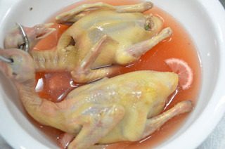 脆皮乳鸽,把脆皮水的原料混合均匀,把烫过的乳鸽放入在脆皮水中滚上几滚,让其全身都挂上脆皮水,脆皮水的配置方法在下方的小贴士里