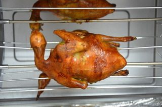 脆皮乳鸽,打开烤箱的旋转开关,让乳鸽边烤边旋转,这样烤出的颜色相对比较均匀。烤箱底部我垫了一张锡纸,这样可以接住滴下来的油,省去清洗烤箱的烦恼