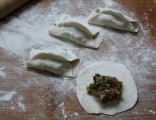 猪肉豆角锅贴,擀成均匀的面皮,上面放入馅料,对折一下,露出两头