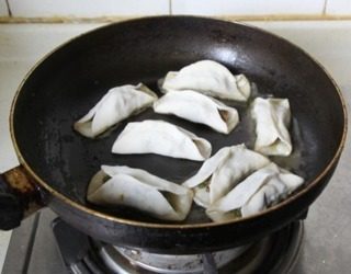 猪肉豆角锅贴,不粘锅中刷一层油,放入锅贴坯子,煎一分钟左右定型一下