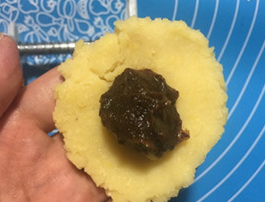 绿豆糕,将绿豆泥揉圆按平,放上枣泥馅