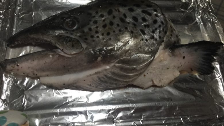 盐烧三文鱼头,烤盘用锡纸包好,烤箱200度预热5分钟。