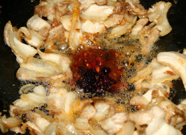 川味回锅肉,将锅中的肉分开，在油中放入<a style='color:red;display:inline-block;' href='/shicai/ 11801'>郫县豆瓣</a>、<a style='color:red;display:inline-block;' href='/shicai/ 491'>老干妈豆豉</a>、<a style='color:red;display:inline-block;' href='/shicai/ 712'>甜面酱</a>、白砂<a style='color:red;display:inline-block;' href='/shicai/ 10588'>糖</a>翻炒均匀。待肉进味后放入青椒、青蒜苗炒至断生即可