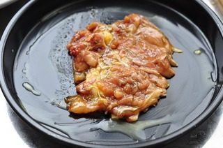 奶酪板栗烤鸡肉,烤盘擦黄油,铺第一块鸡腿肉,有皮的一面在下面