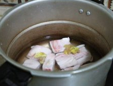 蒜苔回锅猪蹄,猪蹄放入高压锅，加入刚好没过猪蹄的水，再加入拍烂的<a style='color:red;display:inline-block;' href='/shicai/ 2802'>老姜</a>、<a style='color:red;display:inline-block;' href='/shicai/ 692'>酱油</a>、<a style='color:red;display:inline-block;' href='/shicai/ 741'>香叶</a>、白扣。上汤后，小火10分钟；