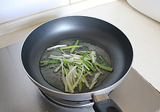 自贡酸菜炒牛肉,平底锅内放入适量<a style='color:red;display:inline-block;' href='/shicai/ 849'>花生油</a>,放入葱姜丝煸炒出香味。
