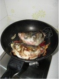 鱼头炖豆腐,中火煎至鱼皮金黄后翻面，继续中火煎制