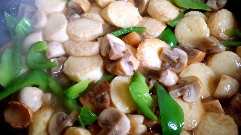 蘑菇烧玉子豆腐,放入煎好的玉子豆腐,炝料酒,加少量开水盖锅盖焖一会。淀粉加水搅匀,淋到锅里翻炒一会。