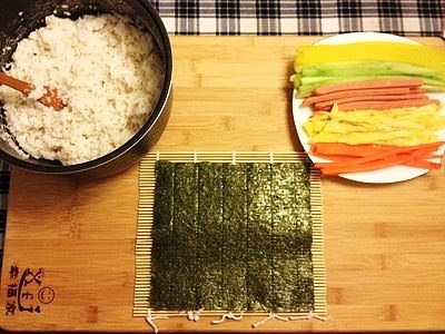 寿司,寿司帘上放上紫菜片，取拌好的米饭均匀铺满！