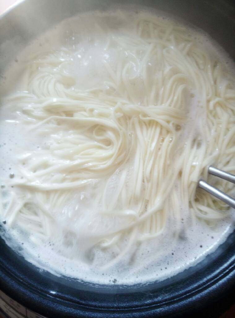 煮面条,锅中,烧开水,把面条放下煮软,放入肉和蘑菇继续煮。