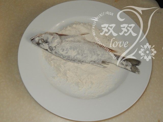 干炸鲈鱼,将鱼放入面粉内,周身裹满面粉