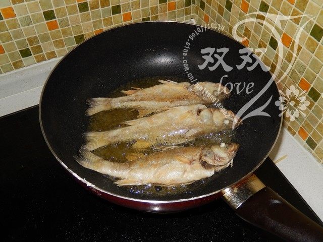 干炸鲈鱼,待鱼煎黄,将其翻面,继续煎