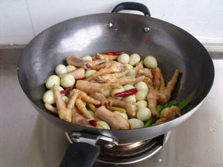 鸡爪烧鹌鹑蛋,倒入鸡爪和<a style='color:red;display:inline-block;' href='/shicai/ 12'>鹌鹑蛋</a>，炒到鸡爪外面微黄