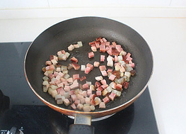 豌豆藕丁炒腊肉,平底锅内放少量的<a style='color:red;display:inline-block;' href='/shicai/ 849'>花生油</a>,先下比较肥的腊肉丁翻炒一下,再下瘦一些的腊肉丁翻炒均匀。