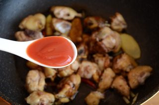 红焖栗子鸡,放入鸡块翻炒,淋入料酒和老抽翻炒上色,加1勺番茄沙司