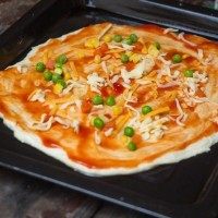 培根披萨,撒点乱七八糟的<a style='color:red;display:inline-block;' href='/shicai/ 500'>玉米</a>，<a style='color:red;display:inline-block;' href='/shicai/ 456'>青豆</a>，胡萝卜上去，然后，这里可以先铺一层芝士。