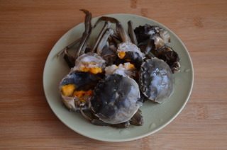 避风塘炒蟹,螃蟹2只刷洗干净,揭掉盖子,去除鳃心胃肠,对半切开,淋一点白酒和一点点盐拌匀