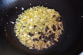 避风塘炒蟹,锅中留余油,放入姜蒜末和豆豉,小火炒出香味