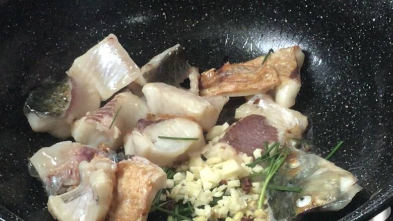 红烧草鱼块,煎至底部金黄,放入葱姜蒜炒香,再同鱼块一起炒匀