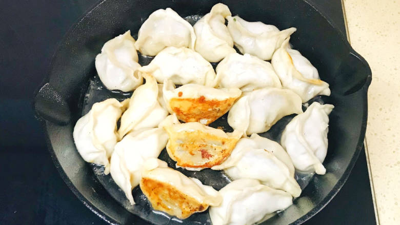 牛肉锅贴,转中火,盖上锅盖,煎煮至水分收干,就可以关火起锅了