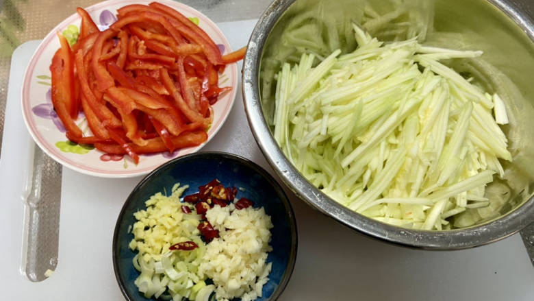 嫩南瓜炒肉丝,改刀:红椒切细丝,南瓜去瓤切粗丝,蒜切蒜末,小米辣切圈,姜切粒,葱白切末