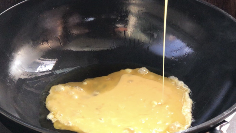 杂炒时蔬,起锅热油,放入蛋液煎熟