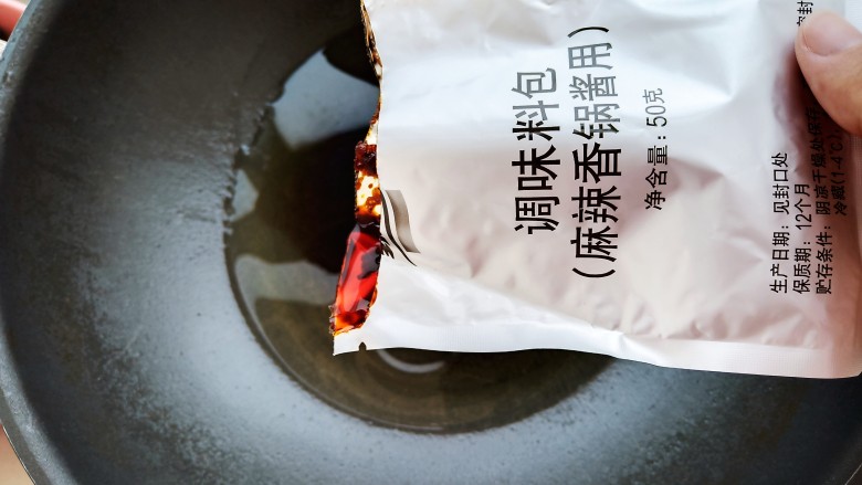 馋哭小孩的麻辣香锅,锅中加入30毫升左右的食用油,加入两包家乐麻辣香锅料。