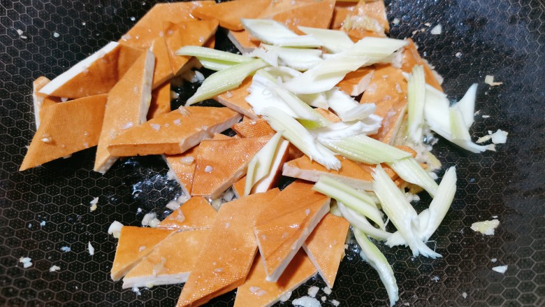 双椒豆干,再加入<a style='color:red;display:inline-block;' href='/shicai/ 125'>芹菜</a>段,加入食用盐翻炒均匀
