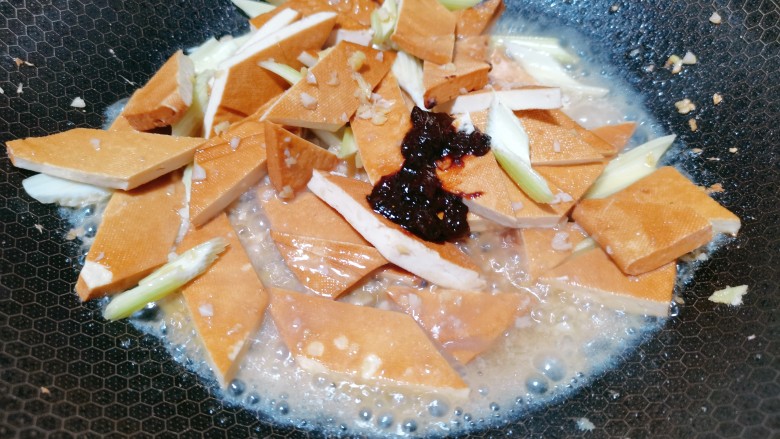 双椒豆干,再加入<a style='color:red;display:inline-block;' href='/shicai/ 705'>豆瓣酱</a>,撒上小半碗清水,翻炒均匀,盖上盖子焖一会