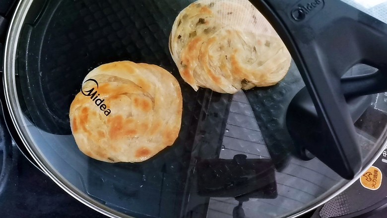 葱油蚕丝饼(饺子皮版),来回翻面烙,盖上盖子能烙的快点,一定不能用电饼铛的上盖盖上去,因为会把饼压的就不