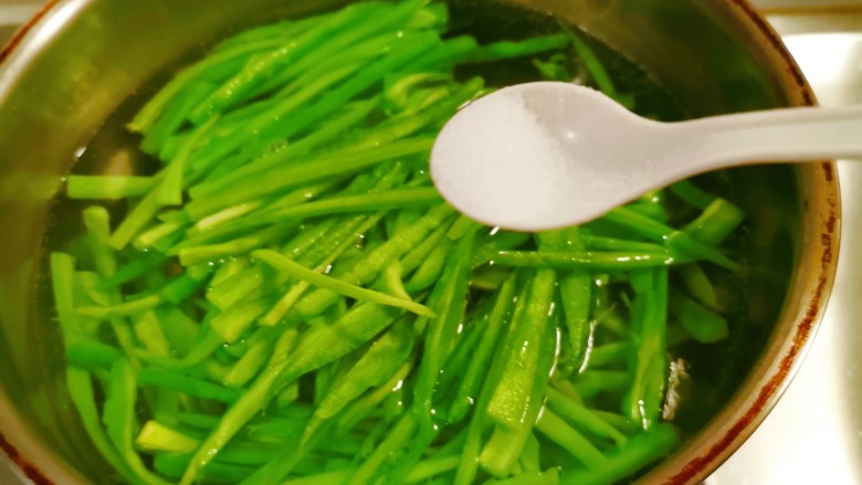 凉拌苦瓜丝,放入开水中,水中加入盐和几滴食用油。