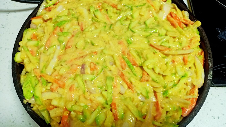 西葫芦 胡萝卜 洋葱 豆面 面粉 玉米面饼,电饼铛预热后 ,两面刷油 ,倒入菜糊摊匀