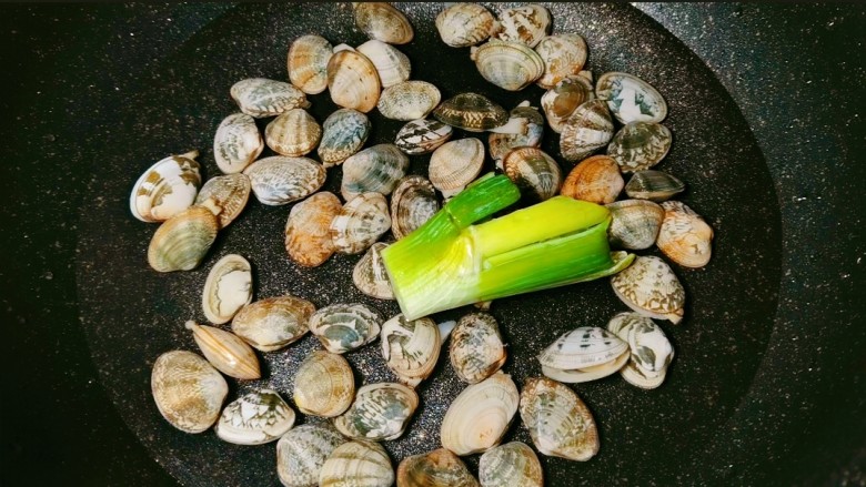 嫩又滑~入口即化蛤蜊蒸蛋,将吐好沙的蛤蜊放入锅内,加入一个葱段。